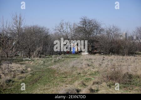 Profondità superficiale di campo dettagli di rifiuti e detriti di costruzione sparsi tutto intorno a un lotto vuoto a Bucarest, vicino a un rifugio improvvisato. Foto Stock