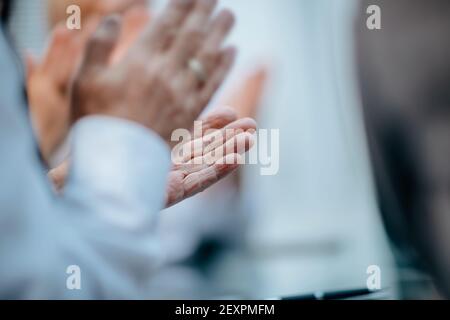 primo piano. gruppo di uomini d'affari che applaudono ad una riunione di lavoro. Foto Stock