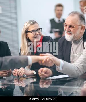 Gli imprenditori maturi scuotono le mani durante le trattative di affari. Foto Stock