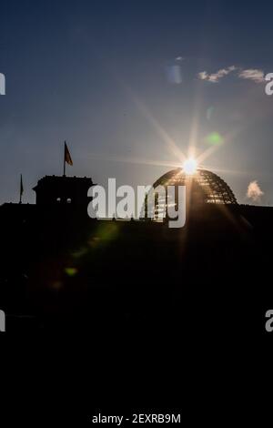 Berlino, Germania. 05 marzo 2021. Il sole sorge dietro la cupola dell'edificio del Reichstag. Credit: Christoph Soeder/dpa/Alamy Live News Foto Stock