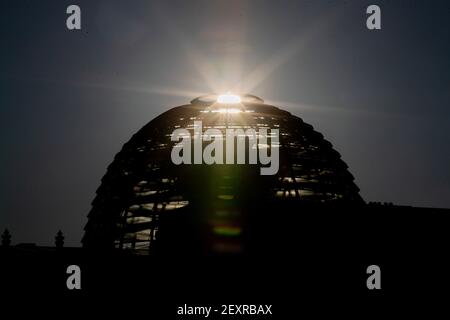 Berlino, Germania. 05 marzo 2021. Il sole sorge dietro la cupola dell'edificio del Reichstag. Credit: Christoph Soeder/dpa/Alamy Live News Foto Stock