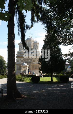 CURTEA DE ARGES, ROMANIA - 21 settembre 2014: Monastero di Curtea de Arges da dietro gli alberi Foto Stock