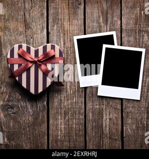 Scatola a forma di cuore e due cornici fotografiche vuote Foto Stock