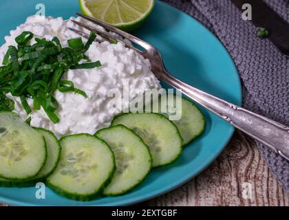 Ricotta con cipolle primaverili e cetriolo affettato su a. piatto di bambù clima-friendly Foto Stock