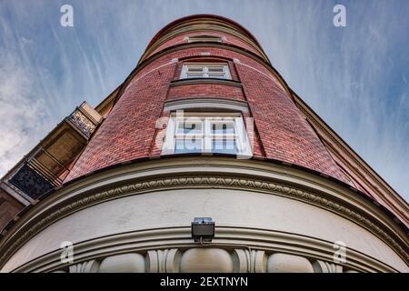 Facciata cilindrica classica in mattoni con finestre al centro. Edificio neoclassico o arrotondato con esterno in mattoni rossi Foto Stock
