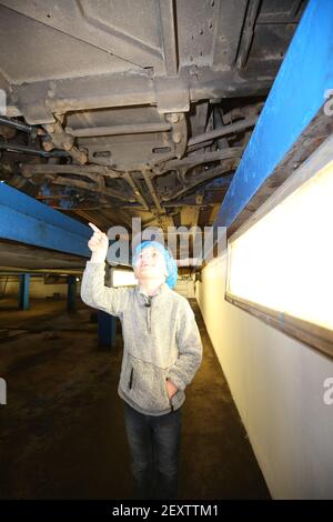 Stagecoach Garage, Kilmarnock, Scozia, Regno Unito 08 aprile 2018. Una giornata aperta al deposito con vari autobus e pullman in mostra, oltre a disservizi e negozi. Una carrozza trainata da cavalli ha dato giri intorno al cortile del garage. La foto mostra un ragazzino che ispetta un autobus dal basso Foto Stock