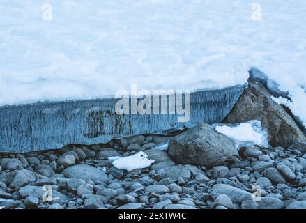 Il ghiaccio blu limpido si è aperto da un ghiacciaio che si scioglie, rivelando il fondale sottostante. Foto Stock