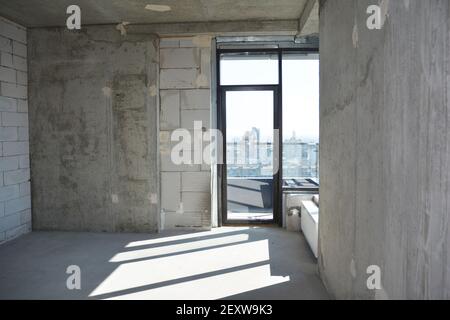 Una vista interna di un appartamento vuoto di nuova costruzione, appartamento senza riparazione con una finestra installata in un edificio residenziale di nuova costruzione. Foto Stock