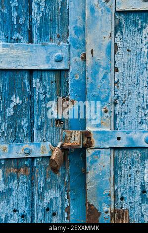 vecchia porta di legno blu in decadimento con serratura di metallo Foto Stock