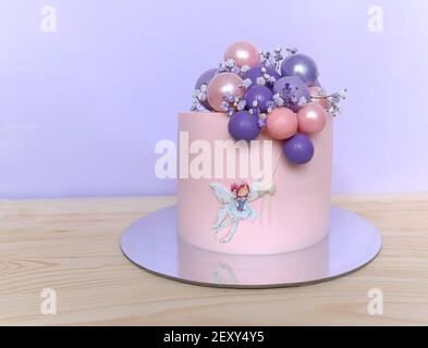 Lilla-rosa festa bella torta con palloncini e una ragazza. Foto Stock