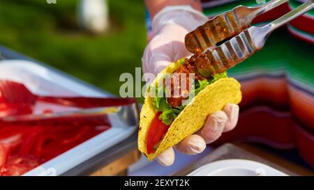 Lo Chef rendendo tacos ad una street cafe Foto Stock