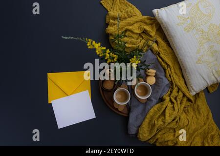 Vista dall'alto di un paio di tazze di caffè su una nuvola di legno a forma di vassoio cerchiato accanto a una busta e un foglio vuoto. Foto Stock