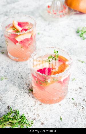 Bicchieri di pompelmo con cubetti di ghiaccio e timo. Cocktail estivi rinfrescanti. Foto Stock