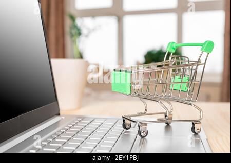 carrello per computer portatili e alimentari. Concetto di shopping online. Carrello acquisti su laptop. Carrello acquisti con computer portatile che negozio web acquista per acquisti online Foto Stock