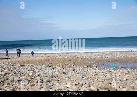 Una vista delle persone che camminano attraverso la spiaggia di Portowan su un Giornata di sole in Cornovaglia Foto Stock