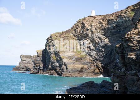 Il sole glorioso sopra le scogliere e l'entrata del porto in Portreath, Cornovaglia Foto Stock