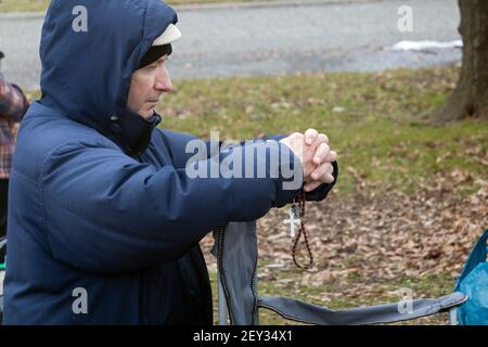 In una fredda giornata invernale, un devoto adoratore cattolico romano con un rosario nel parco nel luogo in cui Veronica Lueken ricevette le sue apparizioni. A NYC. Foto Stock