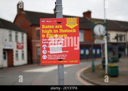 Ibstock, Leicestershire, Regno Unito. 5 marzo 2021. Un cartello di avvertimento covid-19 con la faccia di un adesivo anti-vaccinazione pende da un palo . Il Leicestershire del Nord Ovest ha il tasso più alto di coronavirus in Inghilterra secondo le ultime cifre di sanità pubblica Inghilterra. Credit Darren Staples/Alamy Live News. Foto Stock