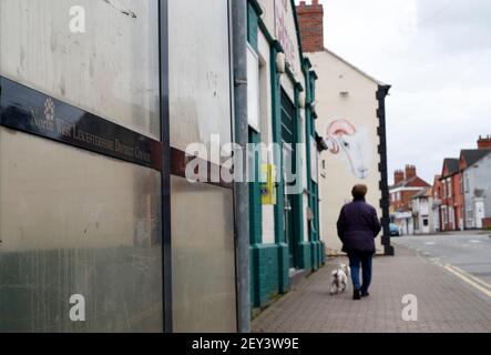 Ibstock, Leicestershire, Regno Unito. 5 marzo 2021. Una donna cammina un cane oltre una fermata dell'autobus. Il Leicestershire del Nord Ovest ha il tasso più alto di coronavirus in Inghilterra secondo le ultime cifre di sanità pubblica Inghilterra. Credit Darren Staples/Alamy Live News. Foto Stock