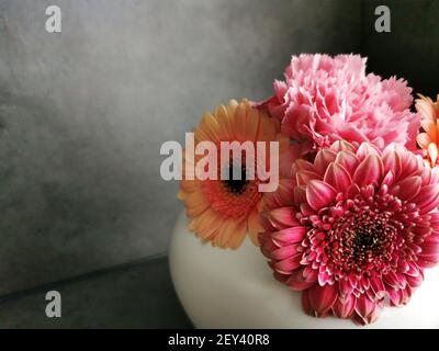Un primo piano di bellissime gerbere colorate in bianco vaso Foto Stock