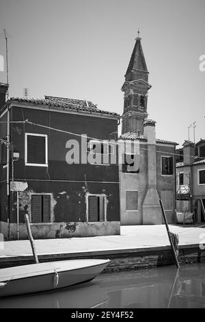 Lungomare di canale e vecchio campanile pendente a Burano a Venezia - Fotografia in bianco e nero, paesaggio urbano italiano Foto Stock