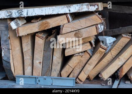 Pila di tavole di legno grezzo non uniformi naturali di diverse dimensioni, vista in sezione. Legname per costruzioni, costruzioni e mobili. Foto Stock