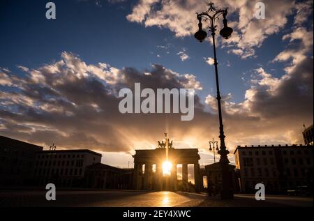 Berlino, Germania. 05 marzo 2021. Il sole tramontante splende attraverso la porta di Brandeburgo. Credit: Christophe Gateau/dpa/Alamy Live News Foto Stock