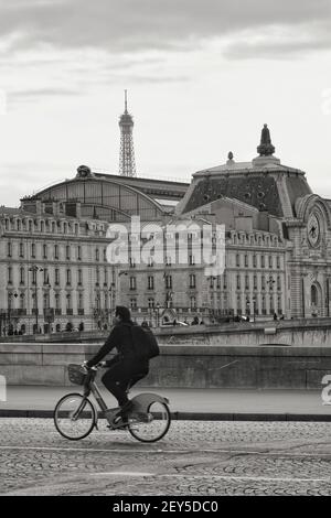 Parigi, Francia - 20 marzo 2019 : un ciclista su un ponte che attraversa la Senna e la Torre Eiffel sullo sfondo di Parigi Francia Foto Stock