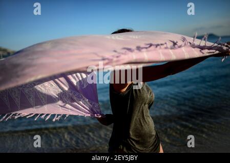 Giovane donna danze sulla spiaggia con sarong Foto Stock