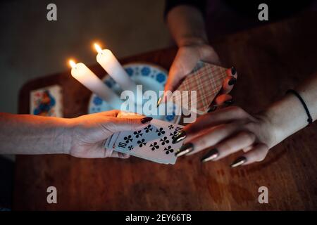 scegli una carta dalle mani di un cassiere di fortuna. una donna racconta le fortune durante un rituale magico. credenza nel misticismo Foto Stock