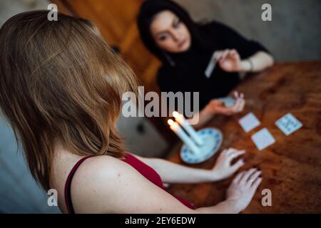 scegli una carta dalle mani di un cassiere di fortuna. una donna racconta le fortune durante un rituale magico. credenza nel misticismo Foto Stock