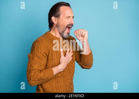 Ritratto fotografico dell'uomo stanco che brilta gli occhi chiusi con un colore marrone pullover invernale a maglia isolato su sfondo di colore blu vivace Foto Stock