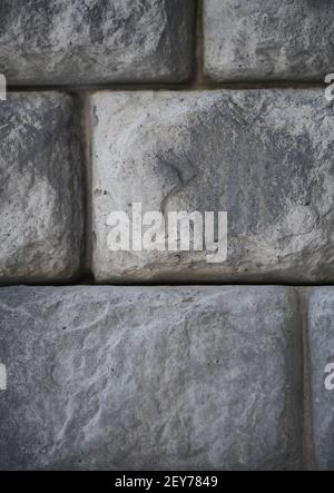 l'uomo ha fatto pietre o rocce a forma di mattoni vicino di pietra pietra muro di mattoni impilati insieme edificio esterno o paesaggio sfondo verticale Foto Stock