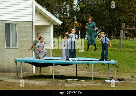 I bambini Amish giocano su un trampolino in una stanza Cantiere scolastico a Sugarcreek e Millersburg Ohio, Ohio Foto Stock