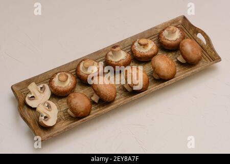 Set di grandi champignons reali su piastra di legno. Foto Stock