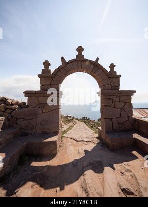 Tradizionale vecchio arco di pietra di pietra benvenuto cancello d'ingresso su Taquile Isola sentiero pedonale Lago Titicaca Puno Perù Sud America Foto Stock