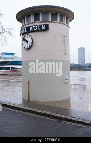 COLONIA, GERMANIA - 07 febbraio 2021: Un colpo verticale dell'indicatore del livello dell'acqua allagato sulla sua base a causa dell'alta marea del fiume Reno a Colonia, Germ Foto Stock