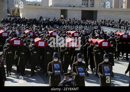 Ankara, Turchia. 5 marzo 2021. I soldati turchi trasportano le casse e i ritratti dei soldati uccisi il giorno prima in un incidente militare dell'elicottero, durante un funerale ad Ankara, Turchia, il 5 marzo 2021. Venerdì il ministro turco della difesa Hulusi Akar ha detto che l'incidente militare dell'elicottero che ha ucciso 11 soldati può essere stato causato da condizioni meteorologiche avverse. Foto Stock