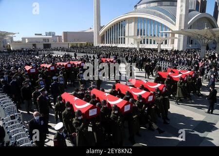 Ankara, Turchia. 5 marzo 2021. I soldati turchi trasportano le casse e i ritratti dei soldati uccisi il giorno prima in un incidente militare dell'elicottero, durante un funerale ad Ankara, Turchia, il 5 marzo 2021. Venerdì il ministro turco della difesa Hulusi Akar ha detto che l'incidente militare dell'elicottero che ha ucciso 11 soldati può essere stato causato da condizioni meteorologiche avverse. Foto Stock