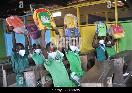 (210305) -- ACCRA, 5 marzo 2021 (Xinhua) -- gli studenti posano con le loro nuove borse scolastiche donate da una società cinese ad Accra, Ghana, il 5 marzo 2021. Un'azienda statale cinese ha donato venerdì un lotto di maschere facciali e di cancelleria per aiutare l'istruzione degli allievi della scuola nella comunità di progetto. Il CRCC Harbour & Channel Engineering Bureau Group Co., Ltd, che intraprende la costruzione del progetto di Jamestown Fishing Port Complex, aiutato dalla Cina, ha donato 500 pezzi ciascuno di maschere facciali e maschere facciali KN95, e cancelleria comprese borse per la scuola, libri per esercizi, penne e matite. (Foto Foto Stock