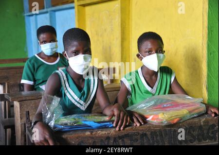 (210305) -- ACCRA, 5 marzo 2021 (Xinhua) -- gli studenti sono visti con le loro nuove borse scolastiche donate da una società cinese ad Accra, Ghana, il 5 marzo 2021. Un'azienda statale cinese ha donato venerdì un lotto di maschere facciali e di cancelleria per aiutare l'istruzione degli allievi della scuola nella comunità di progetto. Il CRCC Harbour & Channel Engineering Bureau Group Co., Ltd, che intraprende la costruzione del progetto di Jamestown Fishing Port Complex, aiutato dalla Cina, ha donato 500 pezzi ciascuno di maschere facciali e maschere facciali KN95, e cancelleria comprese borse per la scuola, libri per esercizi, penne e matite. (PH Foto Stock