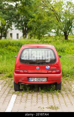 POZNAN, POLONIA - 12 agosto 2017: Fiat Seicento rossa parcheggiata in un parcheggio con erbacce verdi Foto Stock