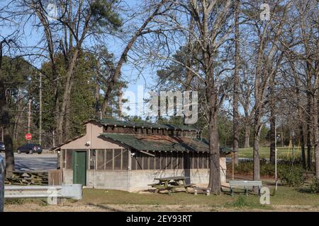 Augusta, GA USA - 03 05 21: Vecchio edificio d'epoca con finestre a schermo e porte verdi con traffico in background Foto Stock