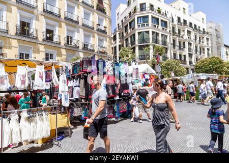 Madrid Spagna Spagnolo Centro El Rastro mercato delle pulci all'aperto Uomo ispanico donna pedoni negozio venditore Foto Stock