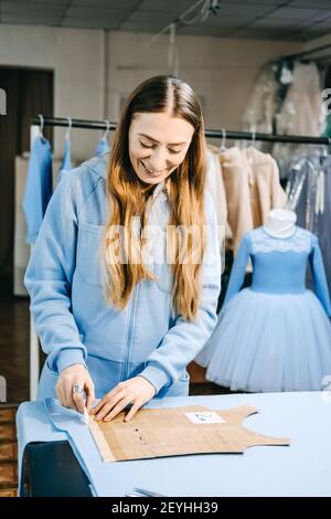 Piccola impresa, stilista di moda, lavoro su misura, lavoro di dressaker. Ritratto candida di stilista di moda che crea outfit, cucire su misura abito su Foto Stock