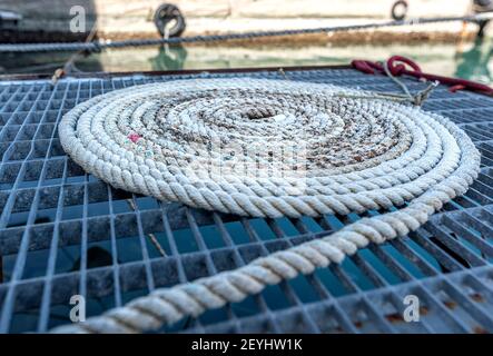 funi realizzate con spiralato in piedi sul molo per ormeggiare la barca a vela Foto Stock