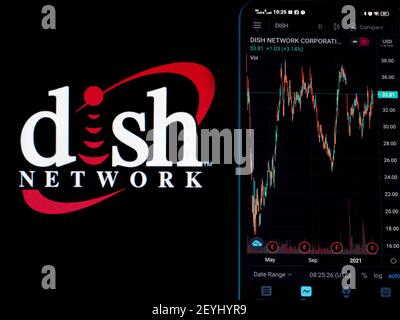 In questa illustrazione della foto le informazioni del mercato azionario di piatto Network Corporation viene visualizzato su uno smartphone mentre il logo di Dish Network Corporation viene visualizzato come sfondo Foto Stock
