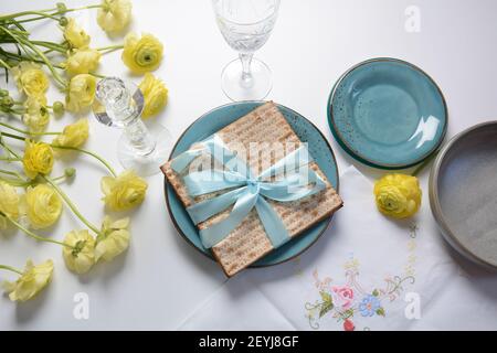 Tavolo servito per la Pasqua (Pesach) al chiuso, con pane matzah come simbolo Pesach (Passover Seder) articolo. Foto Stock