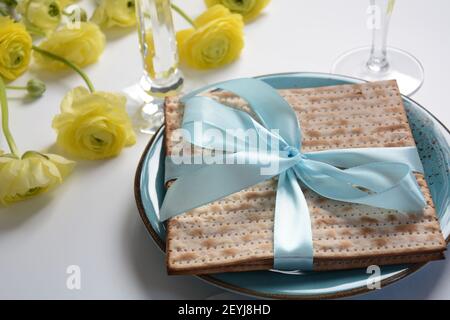 Tavolo servito per la Pasqua (Pesach) al chiuso, con pane matzah come simbolo Pesach (Passover Seder) articolo. Foto Stock