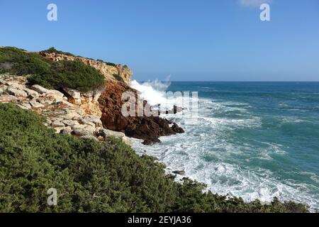 Onde che colpiscono la base delle scogliere nell'algarve occidentale, Portogallo Foto Stock